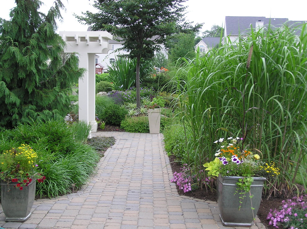 Cette photo montre un grand aménagement d'entrée ou allée de jardin arrière chic au printemps avec une exposition ensoleillée et des pavés en béton.