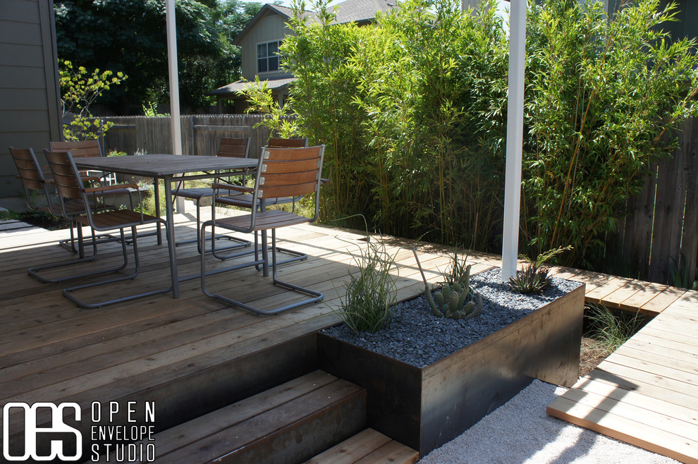 Idee per un giardino xeriscape minimalista esposto a mezz'ombra di medie dimensioni e dietro casa con pedane e un muro di contenimento