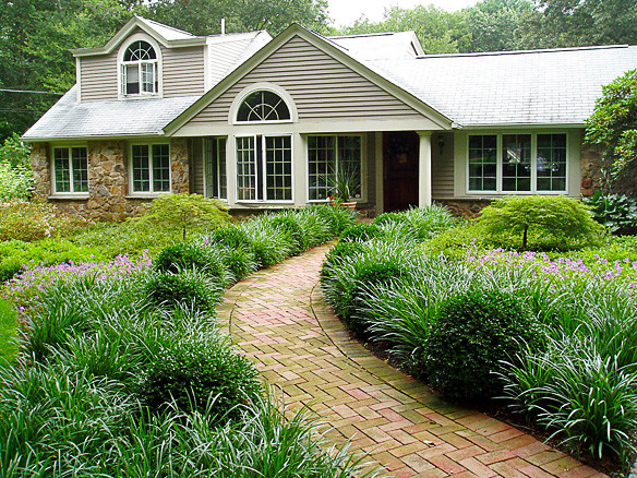 Inspiration for a mid-sized traditional partial sun front yard brick garden path in Providence.