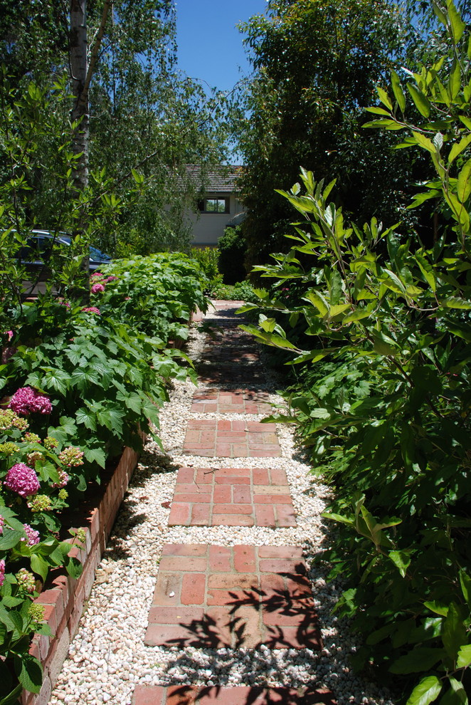 This is an example of a traditional garden with a potted garden and brick paving.