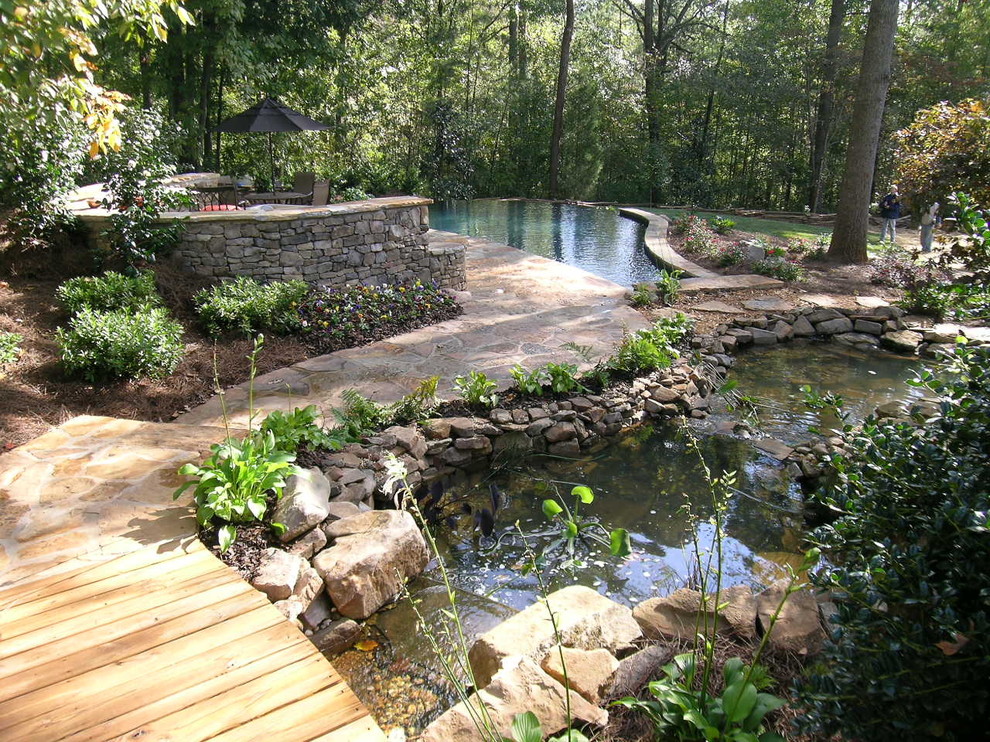 На фото: большой сад с прудом на заднем дворе в классическом стиле с полуденной тенью и покрытием из каменной брусчатки