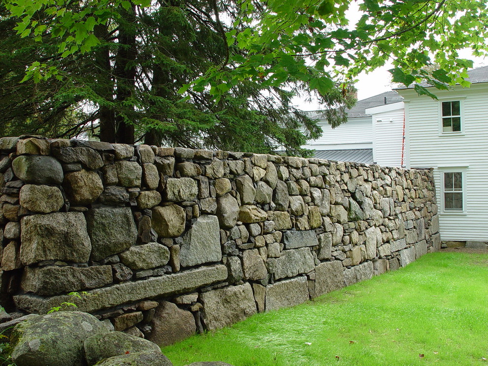 Photo of a large traditional partial sun side yard stone retaining wall landscape in Boston for summer.