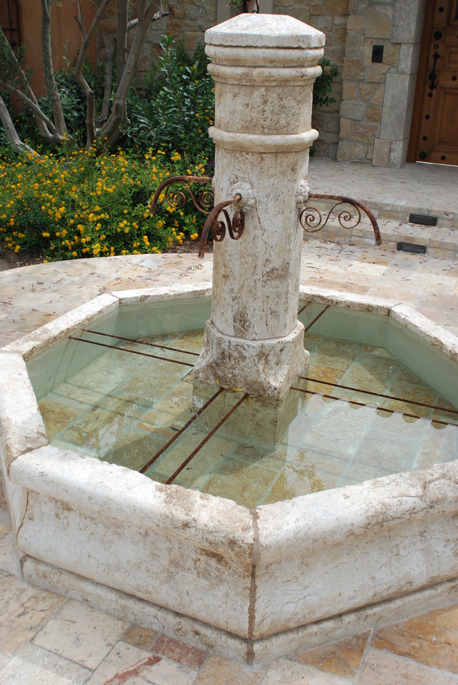 Idée de décoration pour un grand jardin arrière méditerranéen avec un point d'eau, une exposition partiellement ombragée et des pavés en pierre naturelle.
