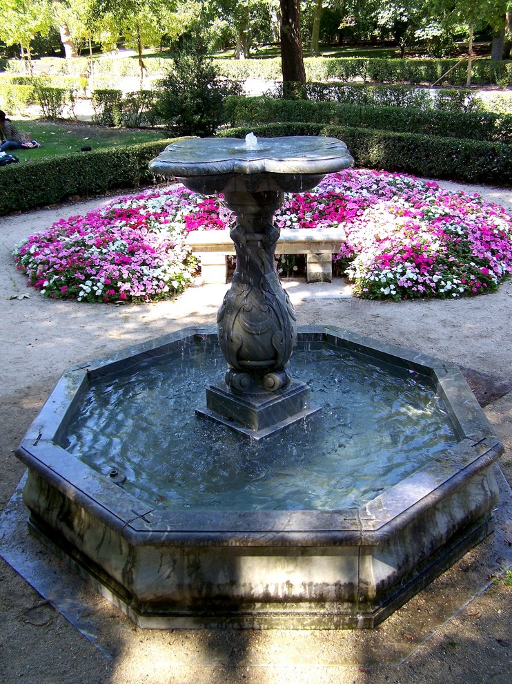 Modelo de jardín mediterráneo grande en patio trasero con fuente, exposición parcial al sol y adoquines de piedra natural