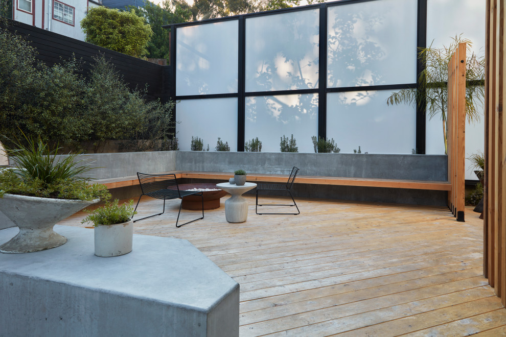 Modelo de jardín de secano minimalista grande en patio trasero con brasero, exposición total al sol y entablado