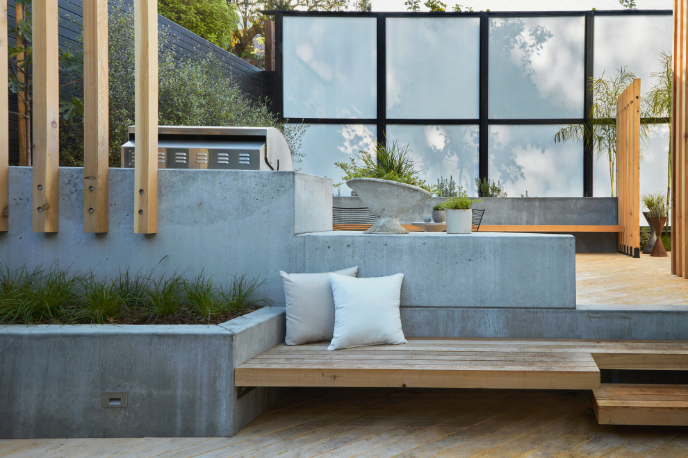 Foto di un grande giardino xeriscape minimalista esposto in pieno sole dietro casa con un focolare e pedane
