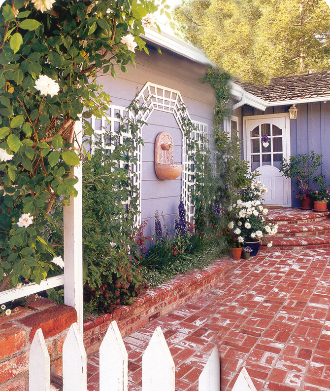 Cette image montre un jardin arrière traditionnel de taille moyenne avec une exposition ensoleillée et des pavés en brique.