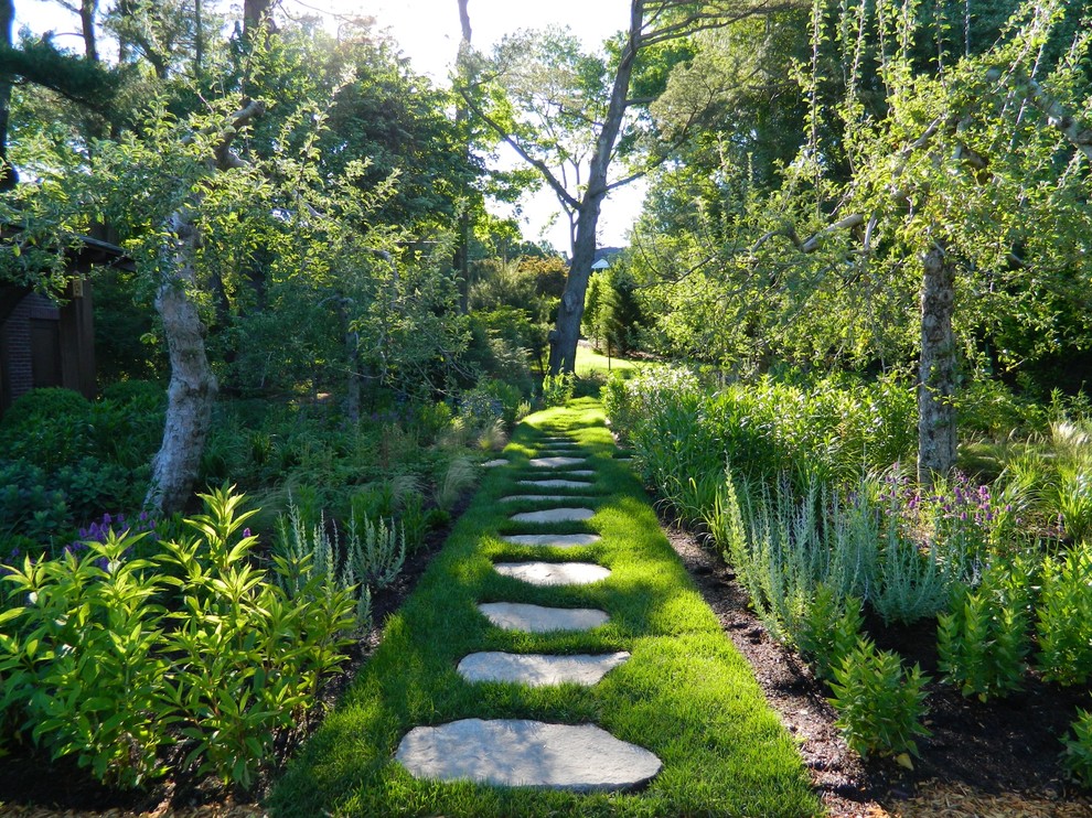 Aménagement d'un grand jardin arrière classique avec des pavés en pierre naturelle.
