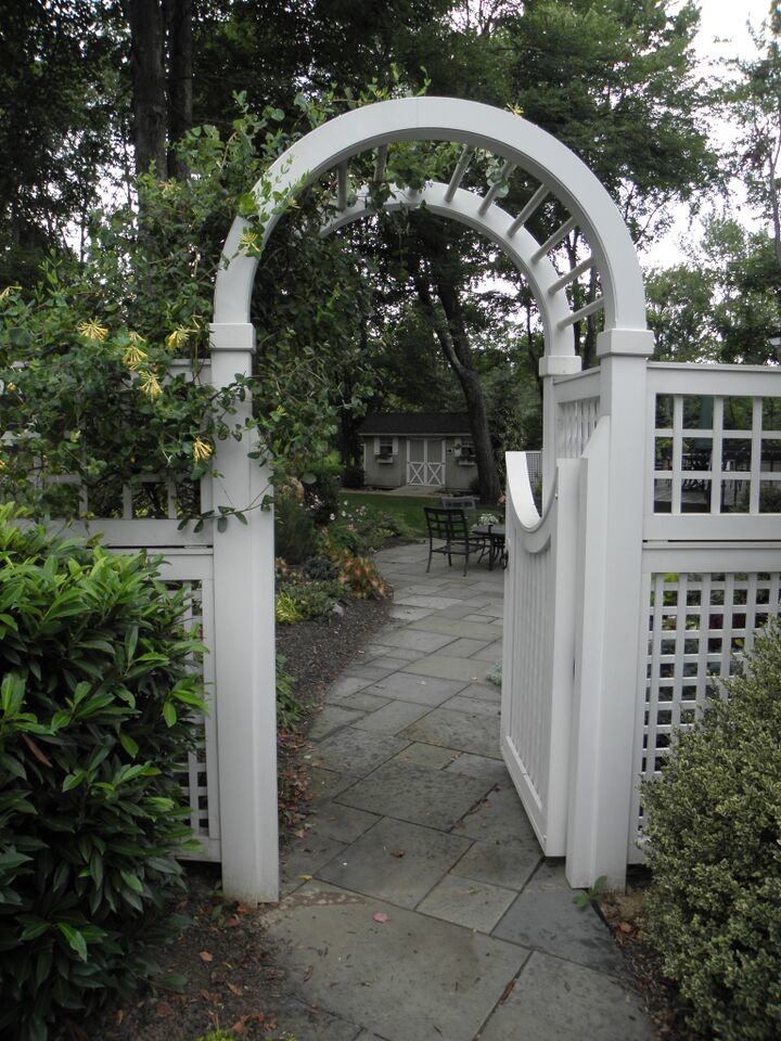 Cette photo montre un aménagement d'entrée ou allée de jardin latéral chic de taille moyenne avec une exposition ombragée et des pavés en pierre naturelle.