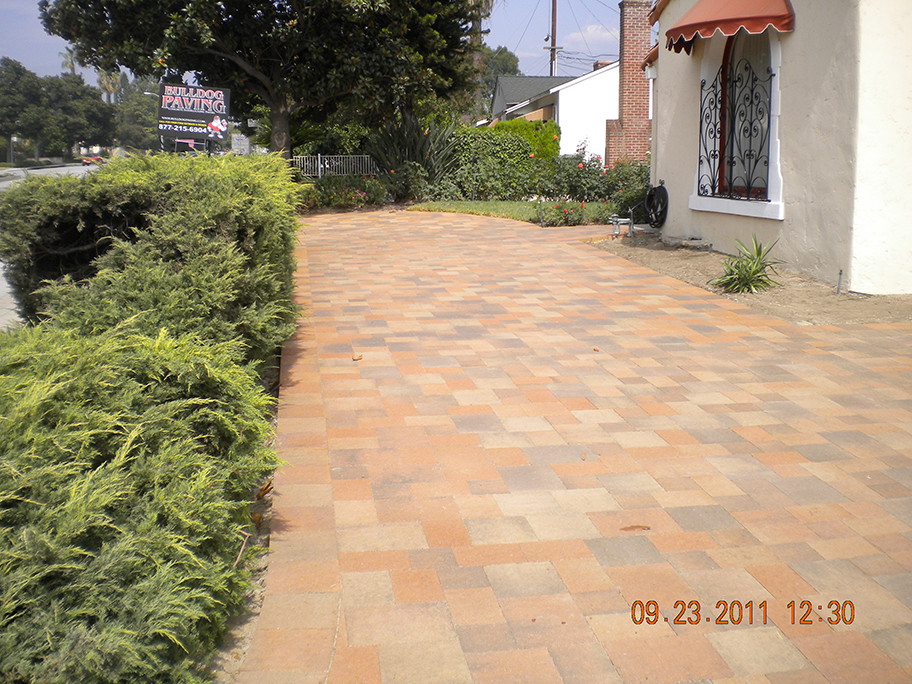 This is an example of a large mediterranean front driveway garden in Los Angeles with concrete paving.