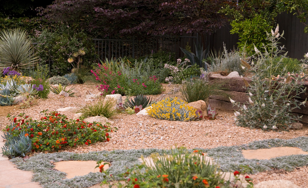 Aménagement d'un grand jardin arrière classique avec une exposition partiellement ombragée et des pavés en pierre naturelle.