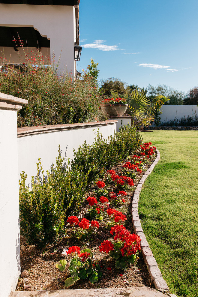 Ejemplo de jardín mediterráneo extra grande en patio trasero con adoquines de ladrillo, jardín francés y parterre de flores