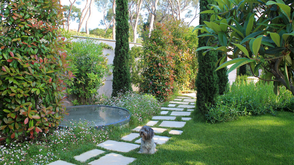 На фото: солнечный участок и сад в средиземноморском стиле с хорошей освещенностью и покрытием из каменной брусчатки