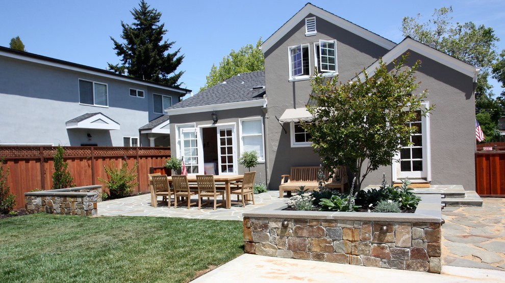 This is an example of a large classic back garden in San Francisco with natural stone paving.