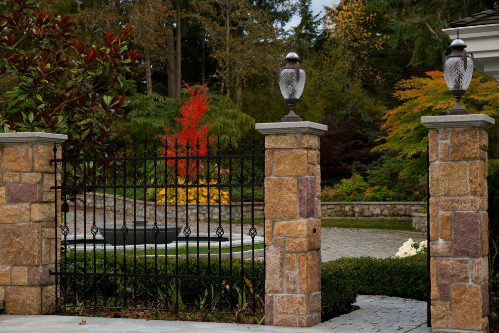Photo of a huge traditional partial sun front yard stone driveway in Vancouver for fall.