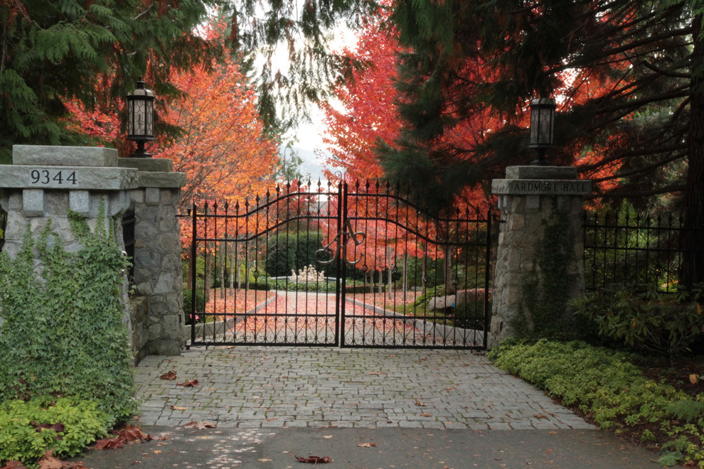 Ispirazione per un ampio vialetto d'ingresso tradizionale esposto a mezz'ombra davanti casa in autunno con pavimentazioni in pietra naturale