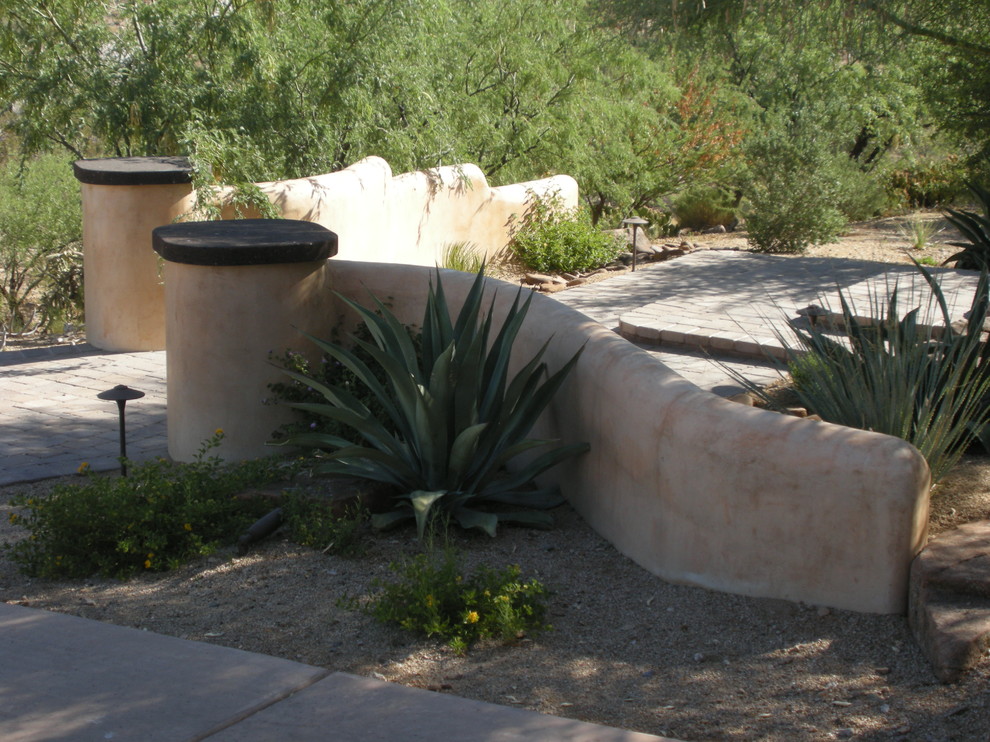 Photo of a mid-sized southwestern drought-tolerant and partial sun front yard brick retaining wall landscape in Phoenix.