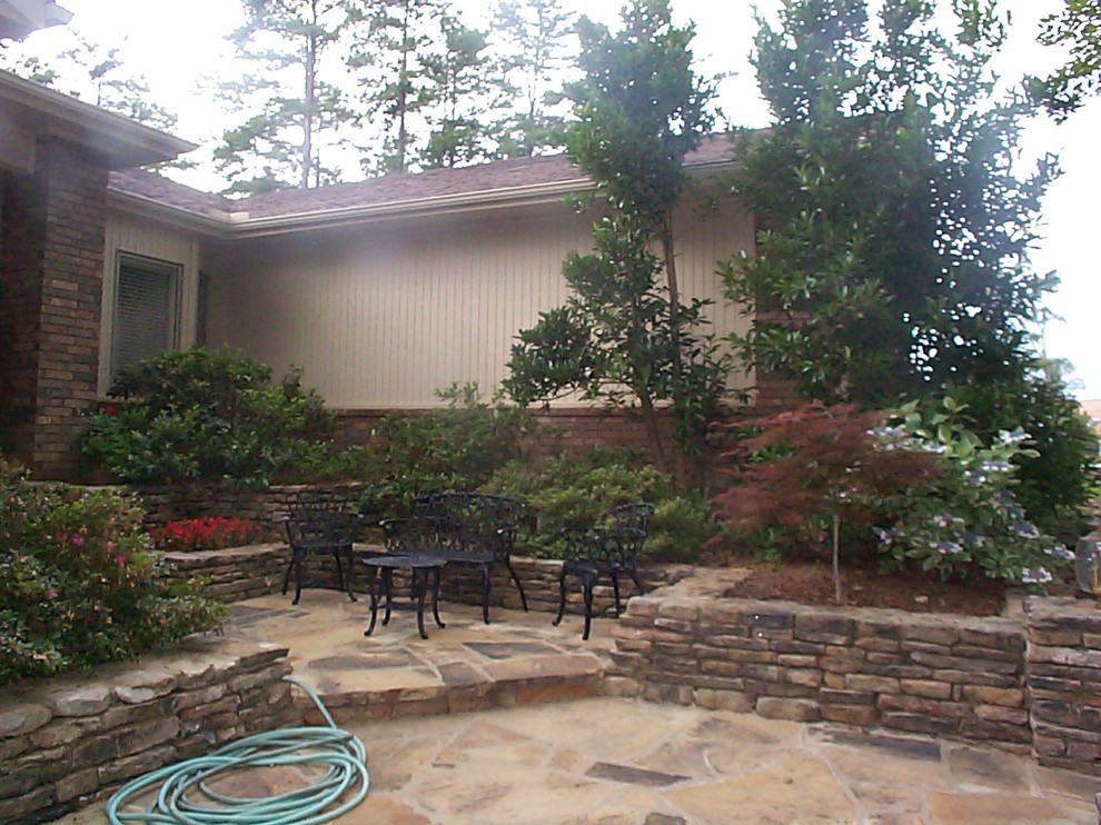 Inspiration for a large rustic partial sun front yard stone landscaping in Little Rock for summer.