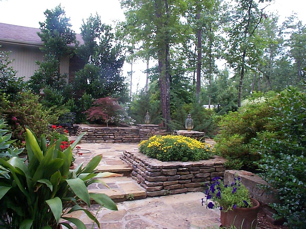 Geometrischer, Großer Rustikaler Garten im Sommer, neben dem Haus mit Blumenbeet, direkter Sonneneinstrahlung und Natursteinplatten in Little Rock
