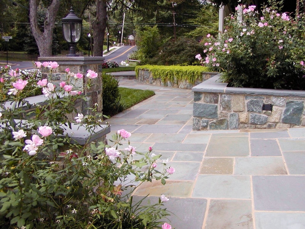 Inspiration for a mid-sized traditional partial sun front yard stone landscaping in DC Metro.