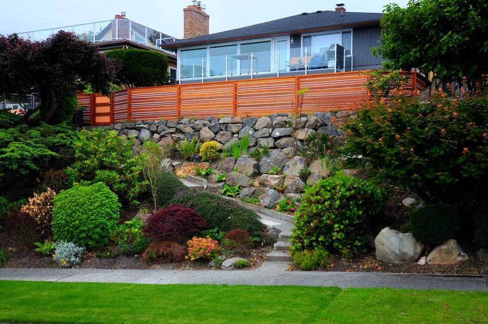 Пример оригинального дизайна: большой солнечный, летний участок и сад на заднем дворе в современном стиле с подпорной стенкой, хорошей освещенностью и покрытием из гравия