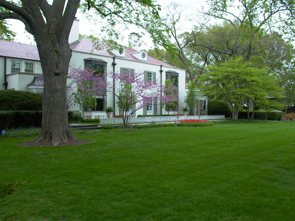 Foto di un giardino minimalista esposto a mezz'ombra di medie dimensioni e davanti casa in primavera con un muro di contenimento e pavimentazioni in pietra naturale