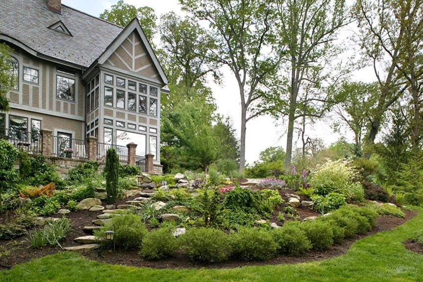 Идея дизайна: большой весенний участок и сад на склоне в классическом стиле с садовой дорожкой или калиткой, полуденной тенью и покрытием из каменной брусчатки