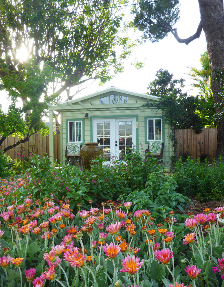 На фото: большой весенний регулярный сад на заднем дворе в классическом стиле с садовой дорожкой или калиткой, полуденной тенью и мульчированием