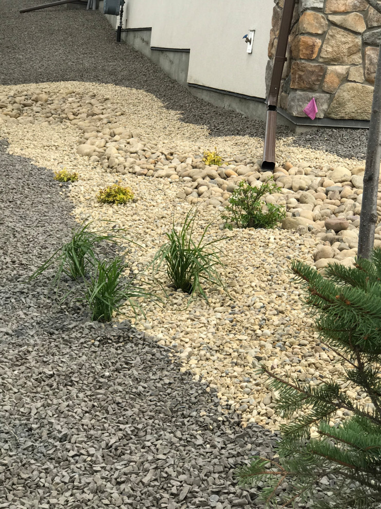 Photo of a large sloped garden in Calgary with a desert look and gravel.