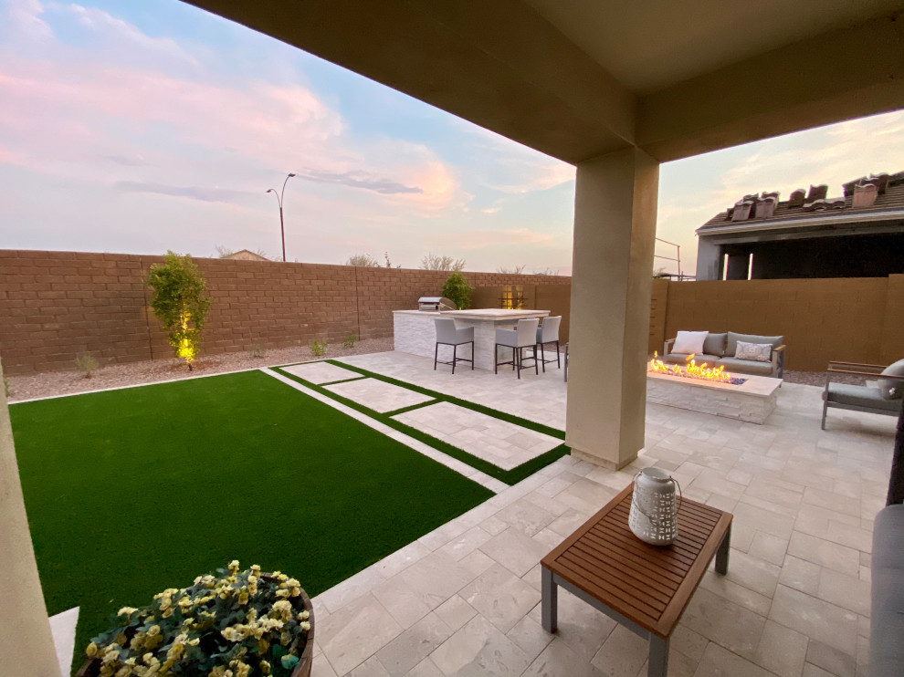 Immagine di un grande giardino minimal esposto in pieno sole dietro casa con pavimentazioni in pietra naturale e recinzione in pietra