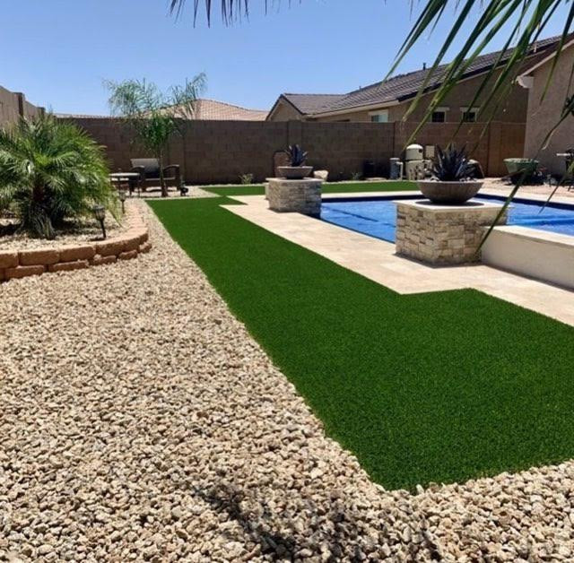 This is an example of a large back xeriscape full sun garden in San Diego with a desert look and decorative stones.