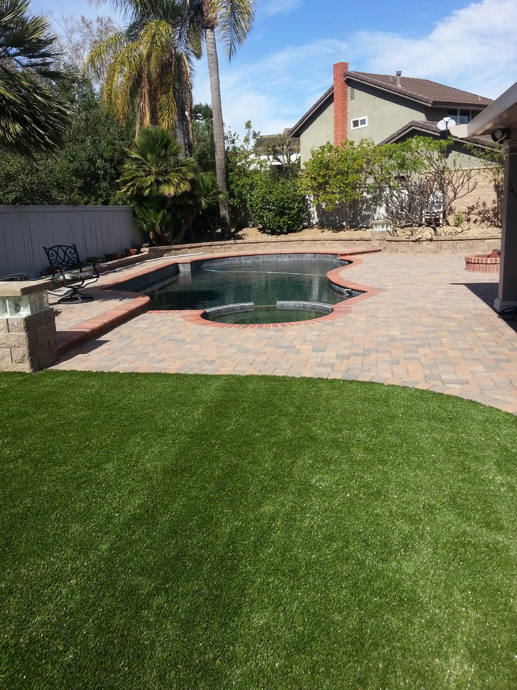 This is an example of a large classic back xeriscape garden in Orange County with brick paving.