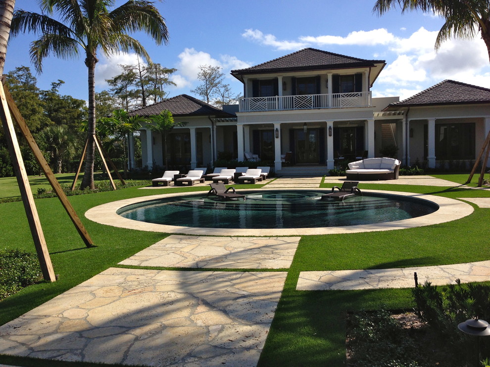 Photo of a large classic back full sun garden in Miami with a garden path and natural stone paving.