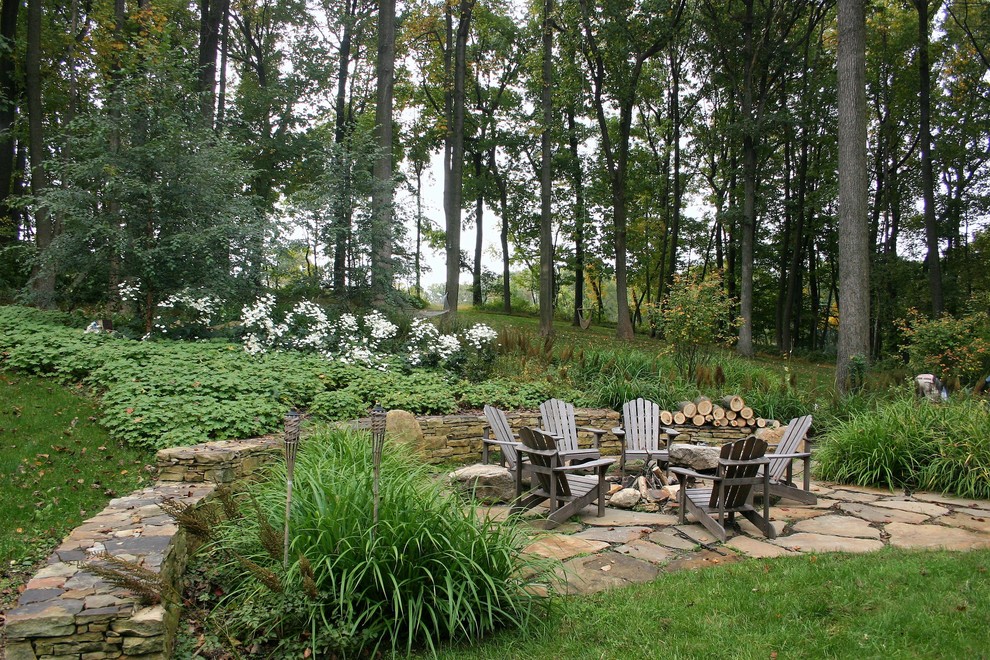 На фото: большой регулярный сад на заднем дворе в стиле рустика с местом для костра, покрытием из каменной брусчатки и полуденной тенью