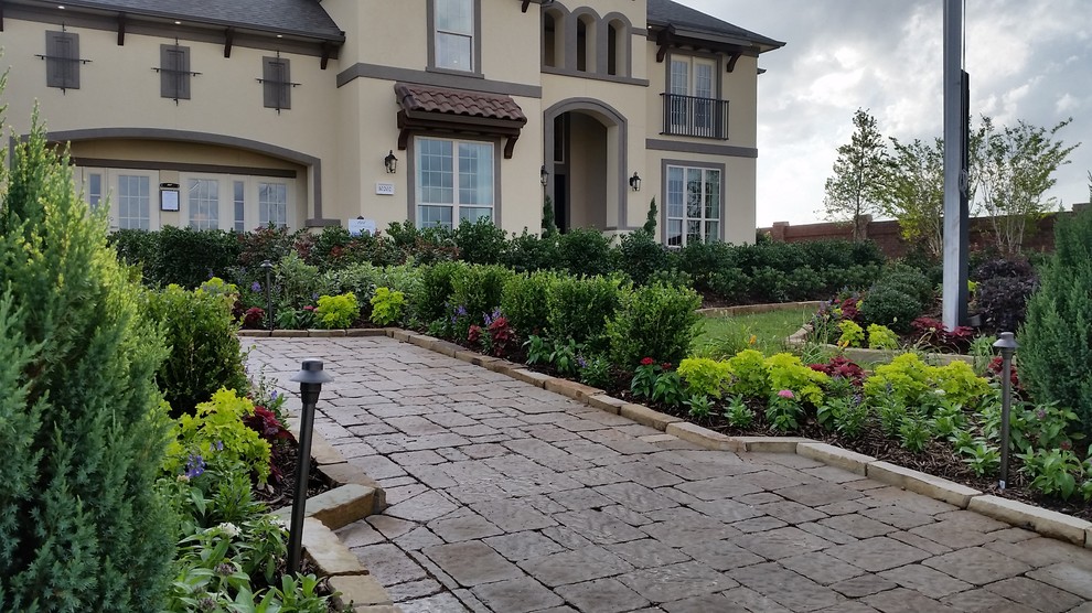 Foto di un giardino formale classico esposto in pieno sole di medie dimensioni e davanti casa con un ingresso o sentiero e pavimentazioni in pietra naturale