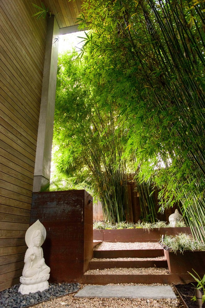 Cette image montre un jardin à la française arrière asiatique de taille moyenne et au printemps avec du gravier, un mur de soutènement et une exposition ombragée.