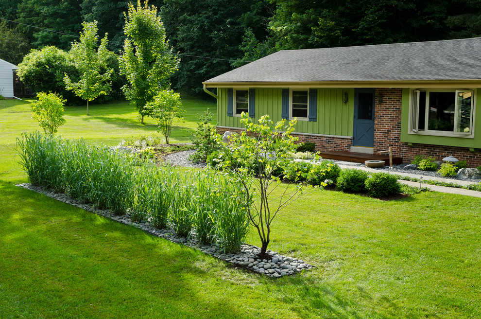 Esempio di un giardino design esposto a mezz'ombra di medie dimensioni e davanti casa con pavimentazioni in pietra naturale