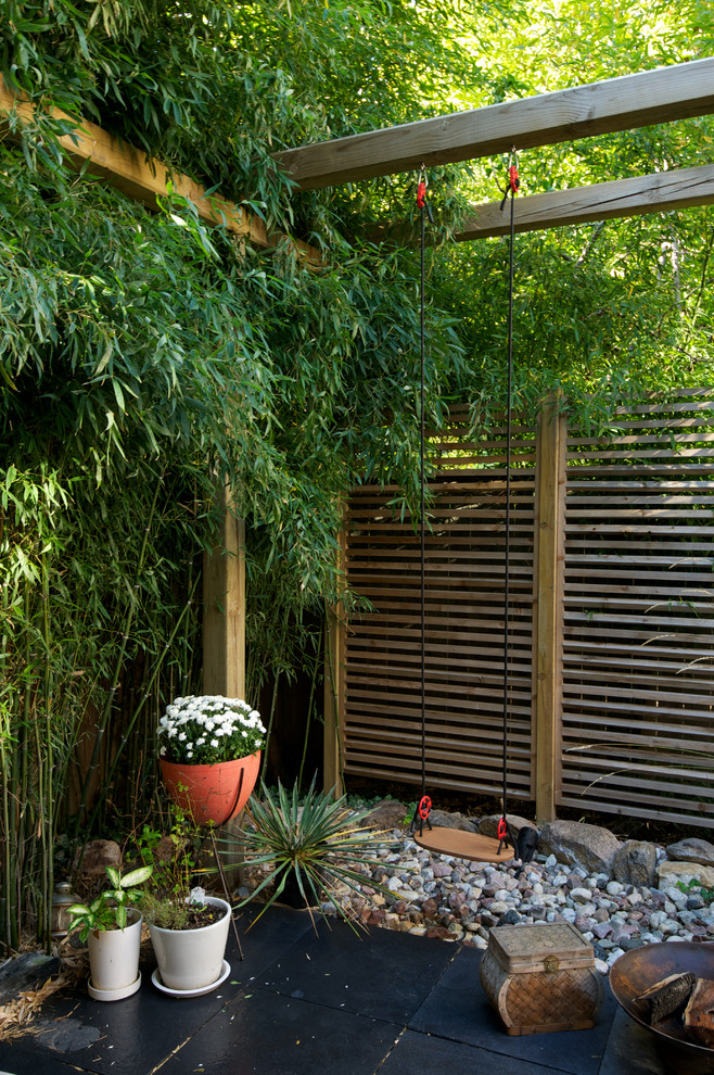 На фото: маленький участок и сад на заднем дворе в восточном стиле с перегородкой для приватности для на участке и в саду
