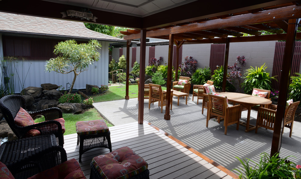 Inspiration för mellanstora asiatiska formella trädgårdar i delvis sol längs med huset på sommaren, med trädäck och en fontän