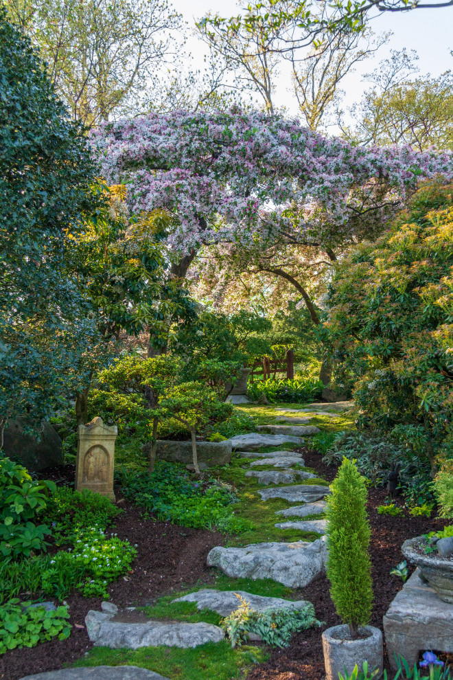 Foto di un grande giardino formale design esposto a mezz'ombra davanti casa in primavera con ghiaia