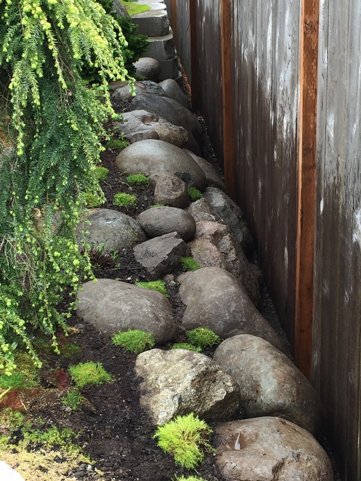 Inspiration for a small asian drought-tolerant backyard stone water fountain landscape in Seattle.