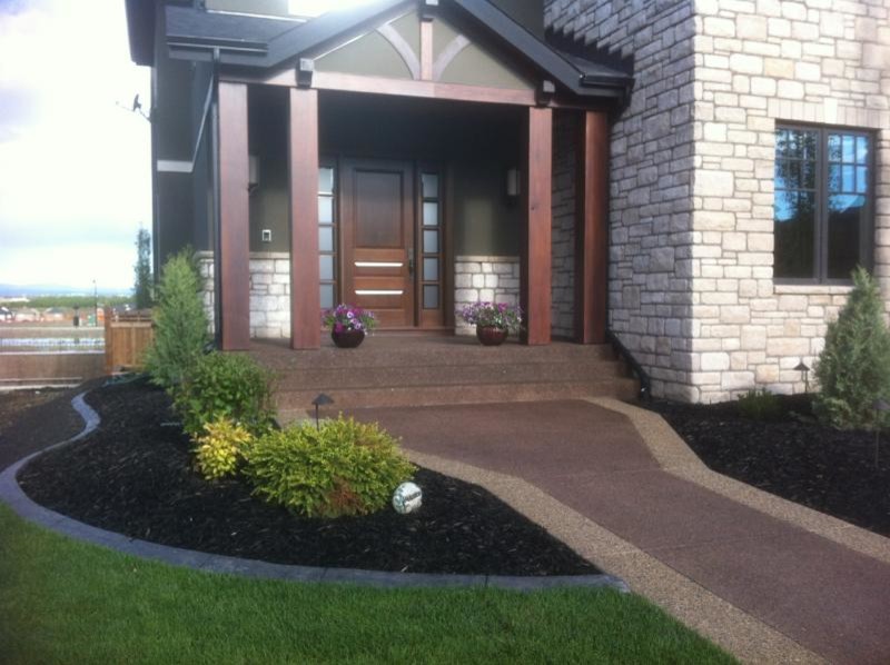 Photo of a mid-sized traditional front yard mulch garden path in Calgary.