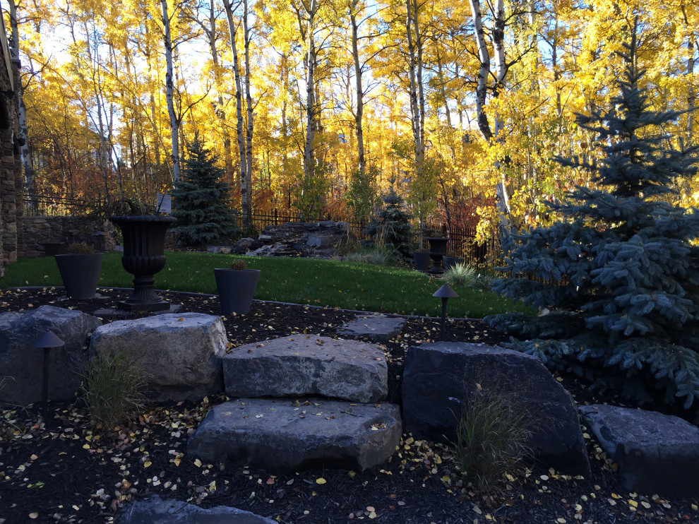 Inspiration for a large traditional drought-tolerant backyard gravel waterfall in Calgary.