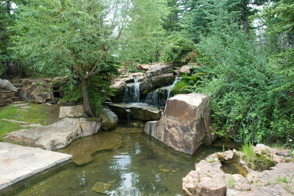 Diseño de jardín rural extra grande en verano en patio delantero con fuente, exposición total al sol y adoquines de piedra natural