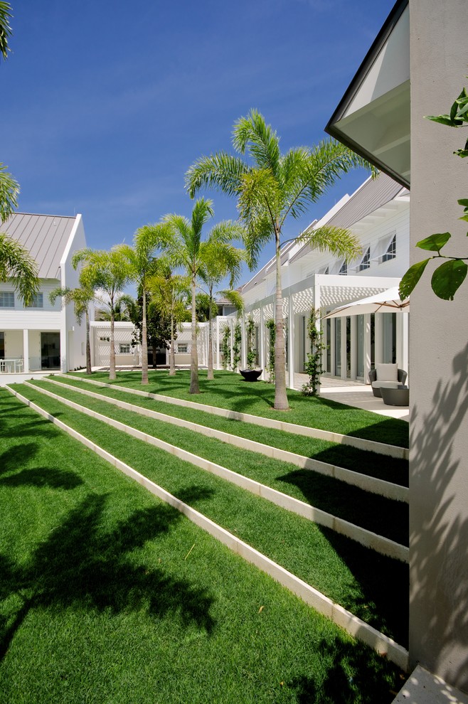 Стильный дизайн: огромный участок и сад на внутреннем дворе в современном стиле с подпорной стенкой и покрытием из каменной брусчатки - последний тренд