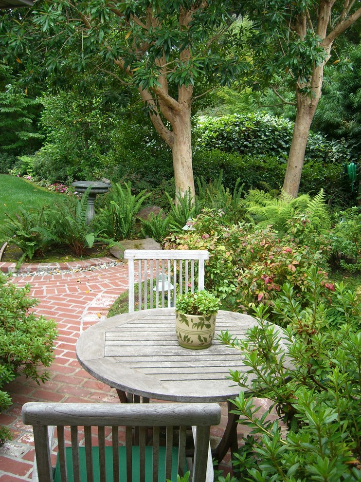 Modelo de jardín clásico en patio trasero con adoquines de ladrillo