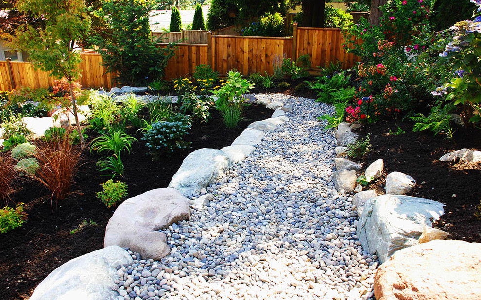 Foto de jardín actual con adoquines de piedra natural y fuente