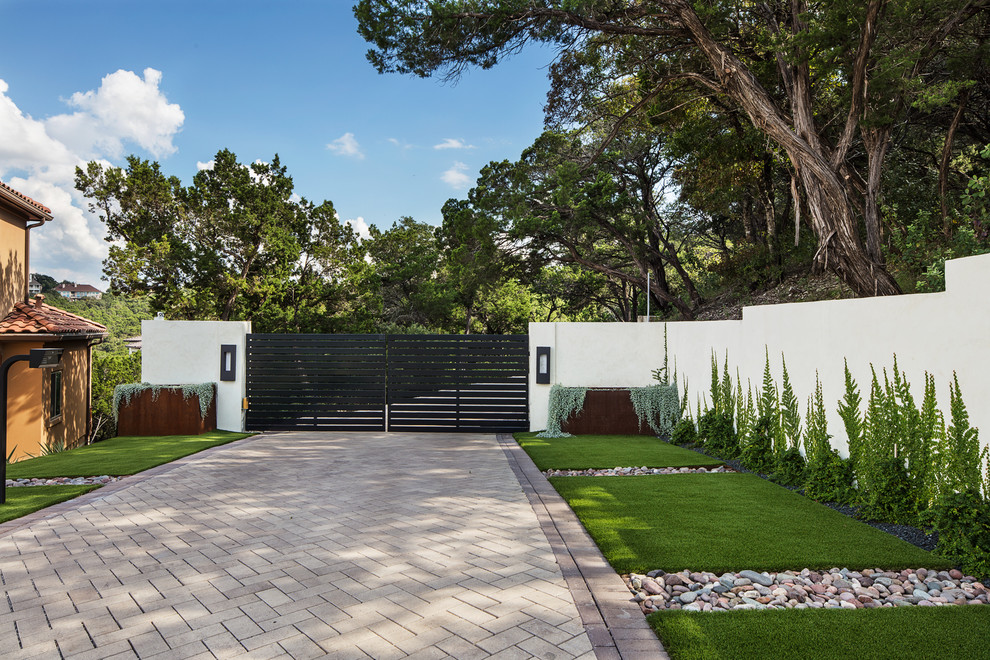 Стильный дизайн: большой солнечный, весенний участок и сад на переднем дворе в стиле модернизм с подъездной дорогой, хорошей освещенностью и мощением тротуарной плиткой - последний тренд