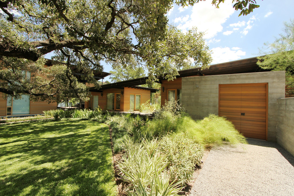 Design ideas for a mid-sized contemporary full sun backyard gravel landscaping in Austin for summer.
