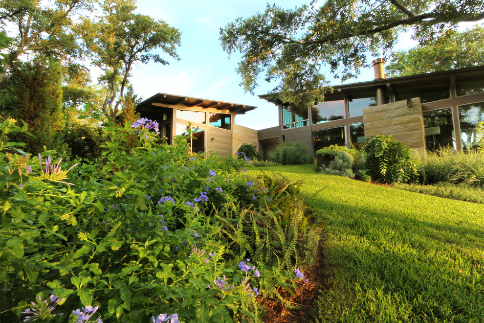 Inspiration for a large modern partial sun hillside landscaping in Austin.